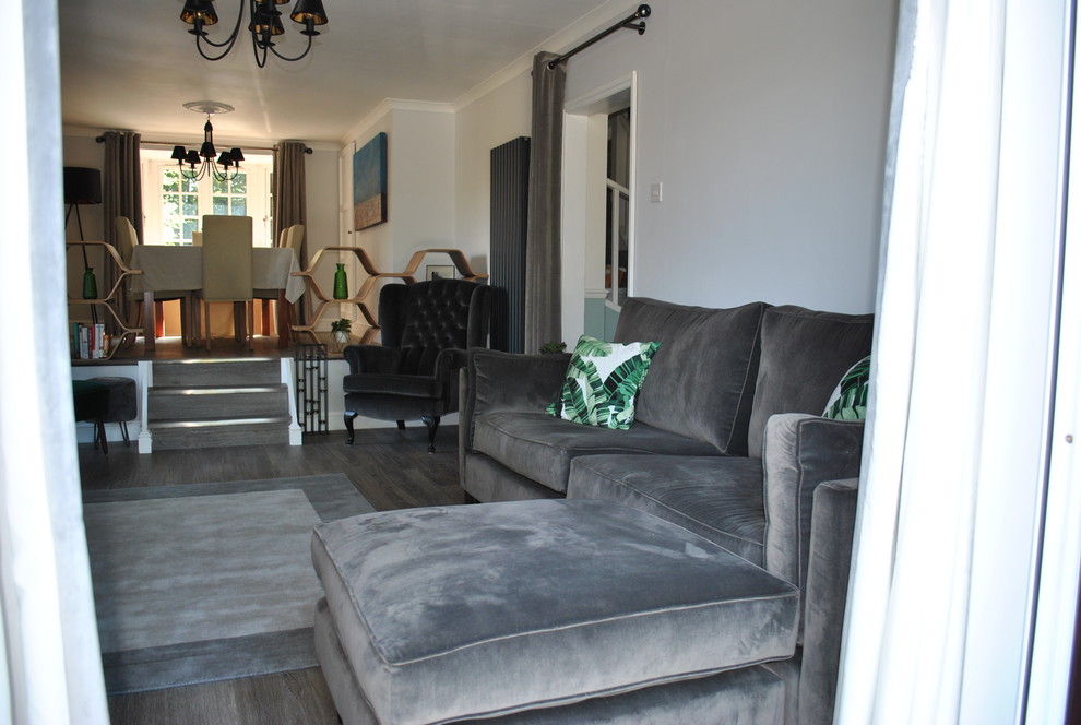 Mittelgroßes Modernes Wohnzimmer im Loft-Stil mit grauer Wandfarbe, Laminat, Kaminofen, gefliester Kaminumrandung, freistehendem TV und grauem Boden in Hertfordshire