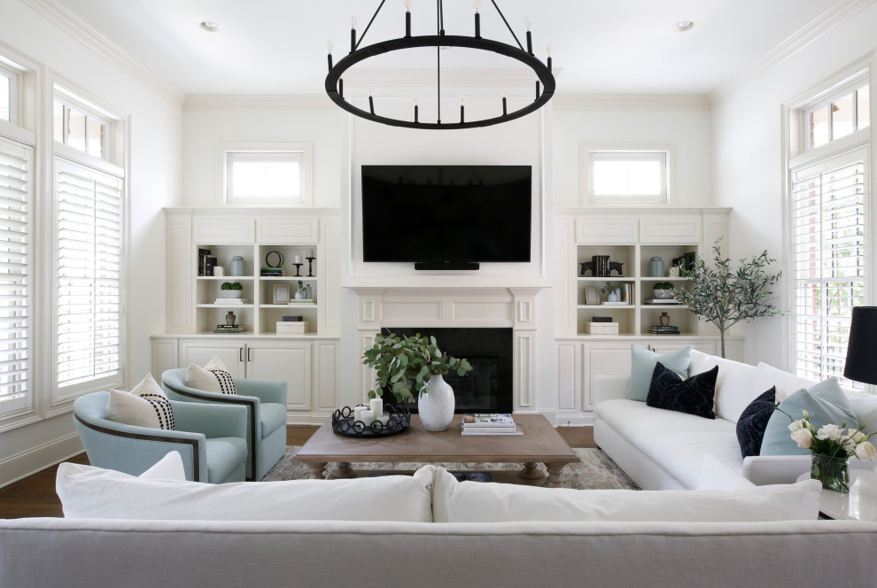 Foto di un soggiorno chic di medie dimensioni e aperto con pareti bianche, parquet scuro, camino classico, TV a parete e pavimento marrone