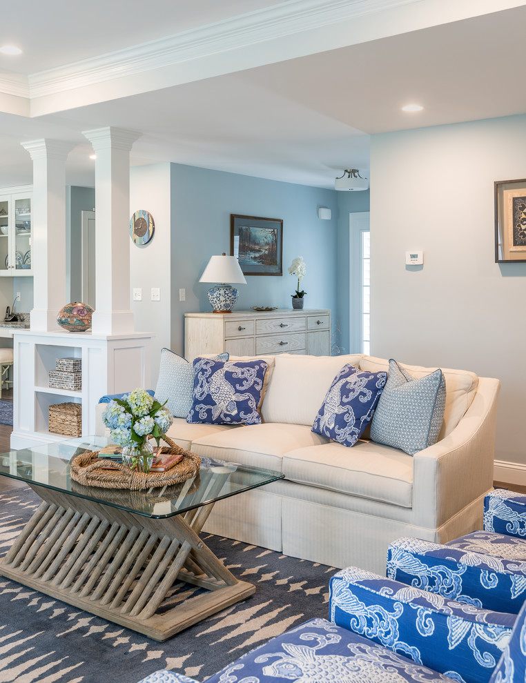 Idée de décoration pour un grand salon marin ouvert avec un mur bleu et parquet foncé.