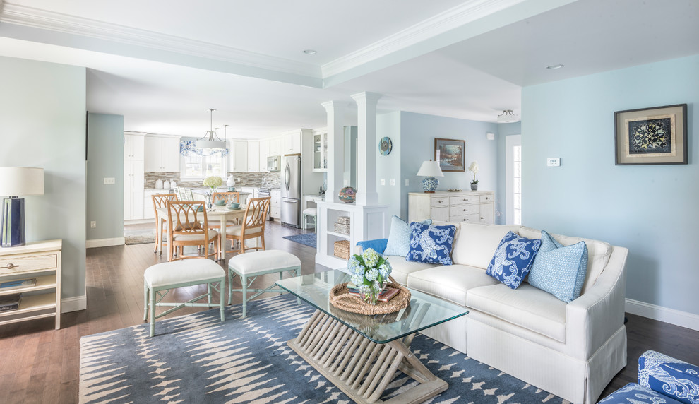 Идея дизайна: большая открытая гостиная комната в морском стиле с синими стенами, темным паркетным полом, стандартным камином и фасадом камина из дерева