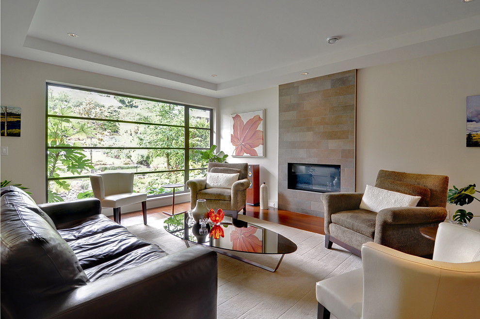 Mittelgroßes, Offenes Modernes Wohnzimmer mit beiger Wandfarbe, braunem Holzboden, Gaskamin und gefliester Kaminumrandung in Vancouver