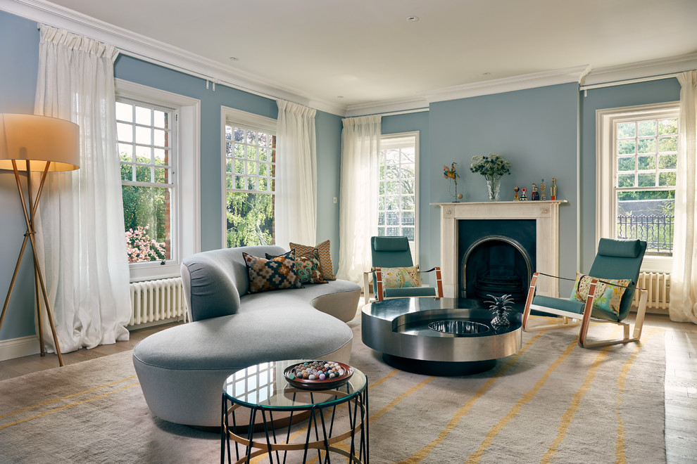 Diseño de salón contemporáneo con paredes azules, suelo de madera en tonos medios, todas las chimeneas y suelo marrón