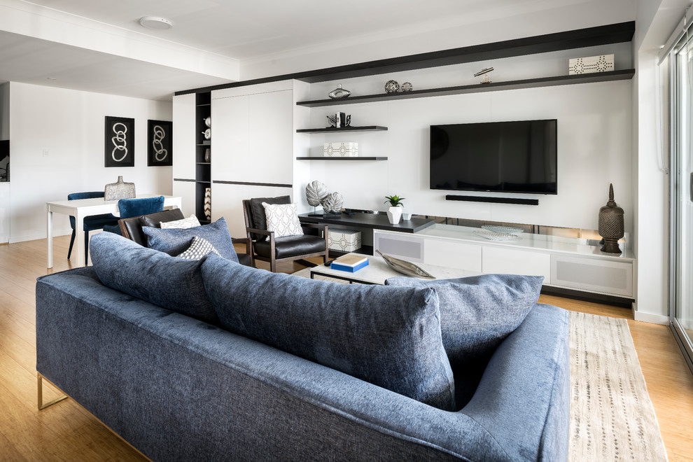 Esempio di un piccolo soggiorno moderno aperto con pareti grigie, parquet chiaro e TV a parete