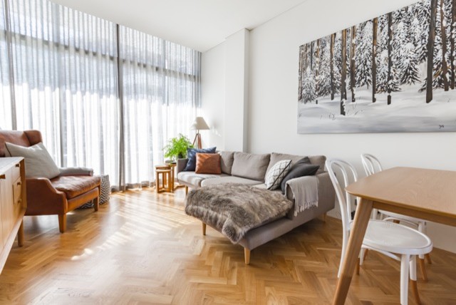Cette image montre un salon nordique ouvert avec un mur blanc, parquet clair et un téléviseur indépendant.
