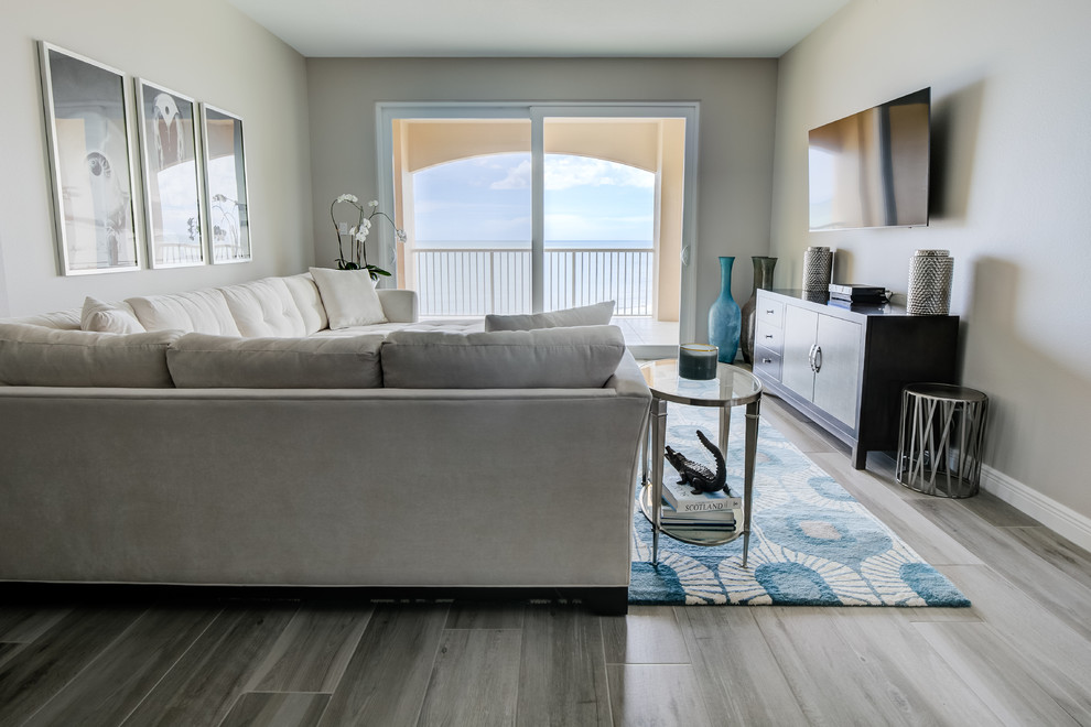 Immagine di un soggiorno stile marino aperto con pareti grigie, pavimento con piastrelle in ceramica, TV a parete e pavimento grigio