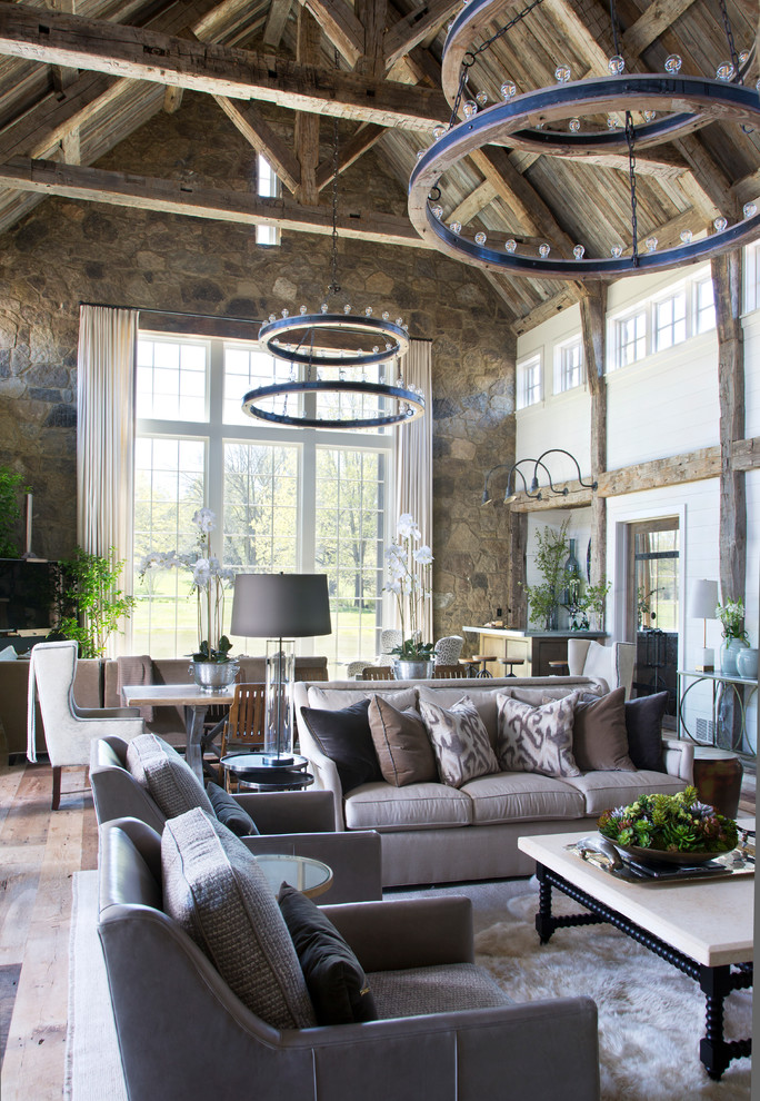 Large farmhouse open concept medium tone wood floor and brown floor living room photo in Austin with white walls, a wood stove, a stone fireplace and no tv