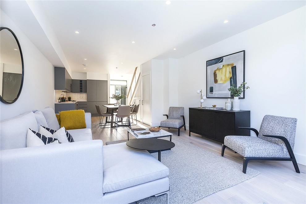 Esempio di un soggiorno design di medie dimensioni e aperto con pareti bianche, pavimento beige e parquet chiaro