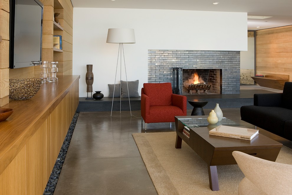 サンフランシスコにある広いコンテンポラリースタイルのおしゃれなLDK (コンクリートの床、タイルの暖炉まわり、白い壁、標準型暖炉、埋込式メディアウォール、黒いソファ) の写真