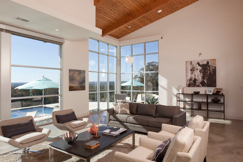 Großes Modernes Wohnzimmer mit weißer Wandfarbe und Betonboden in Austin