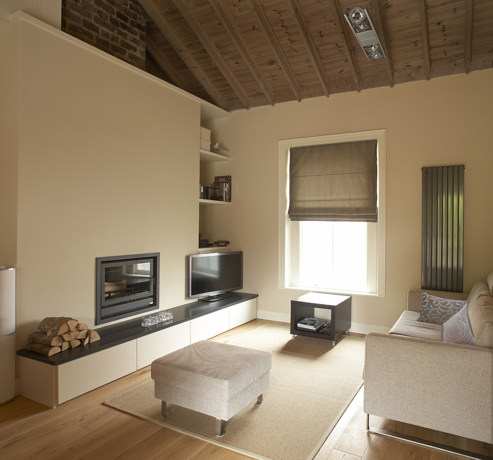 Diseño de salón moderno de tamaño medio con paredes beige y televisor independiente