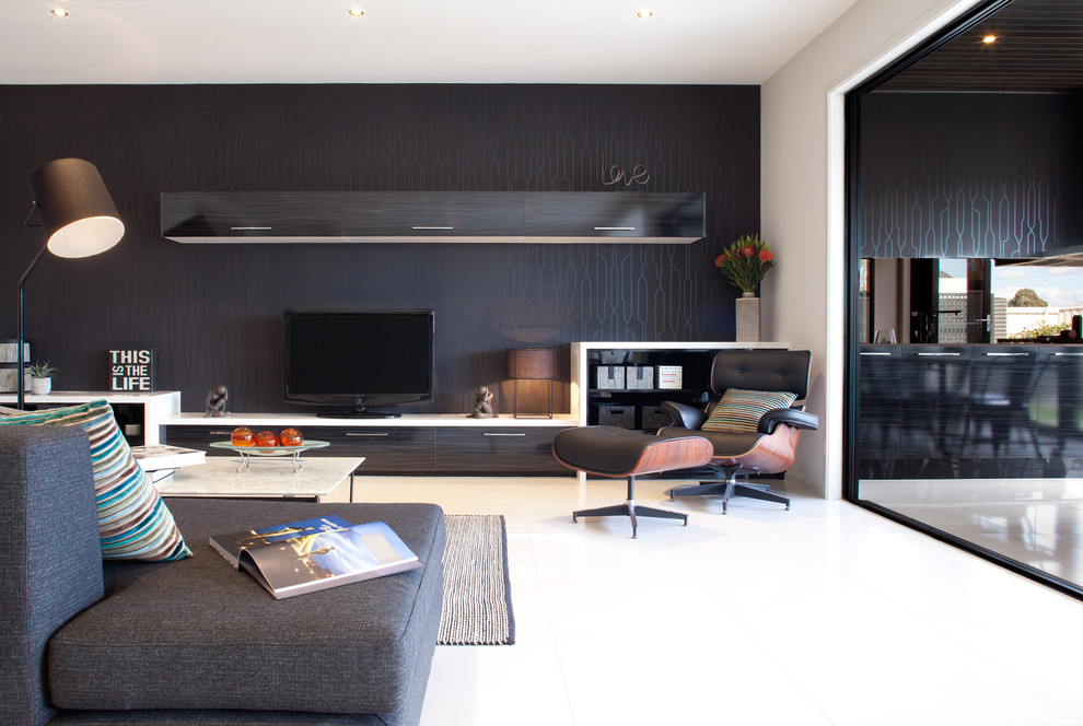 Стильный дизайн: гостиная комната в современном стиле с черными стенами, отдельно стоящим телевизором, акцентной стеной, ковром на полу и обоями за телевизором - последний тренд