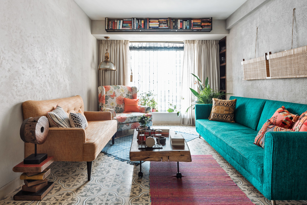 This is an example of a bohemian living room in Mumbai with grey walls and brown floors.