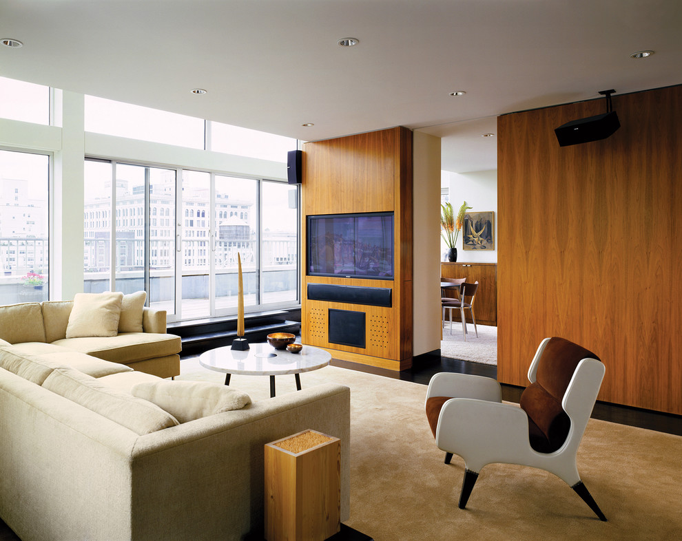 This is an example of a large contemporary living room in New York with a built-in media unit.