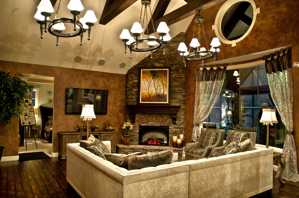This is an example of a large traditional open plan living room in Cleveland with brown walls, dark hardwood flooring, a corner fireplace, a stone fireplace surround and a wall mounted tv.