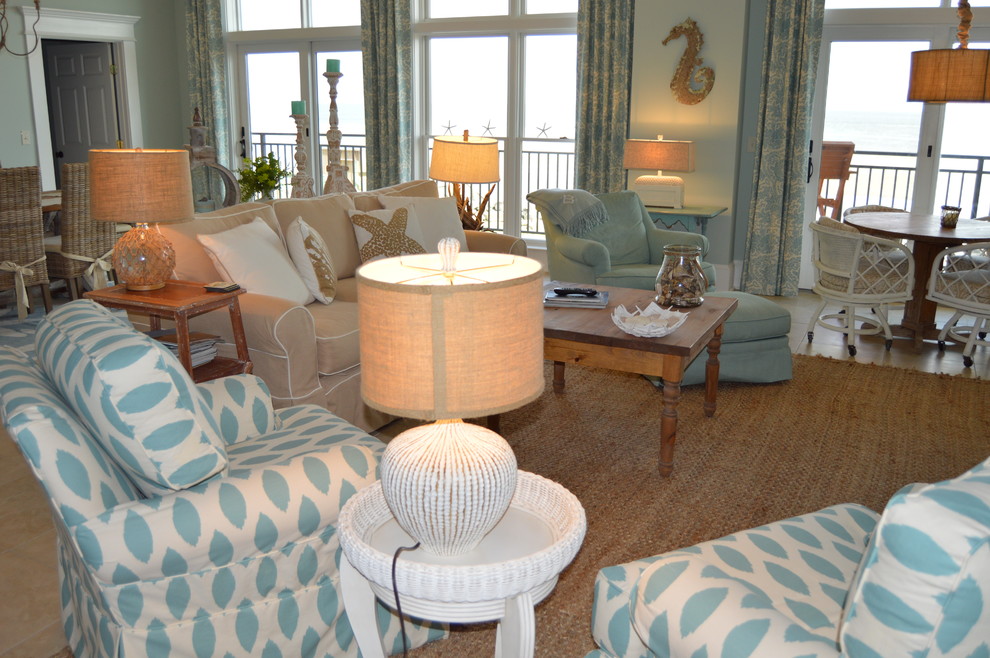 Exemple d'un salon bord de mer de taille moyenne et fermé avec un mur bleu, un sol en calcaire, aucune cheminée, un téléviseur encastré et un sol beige.