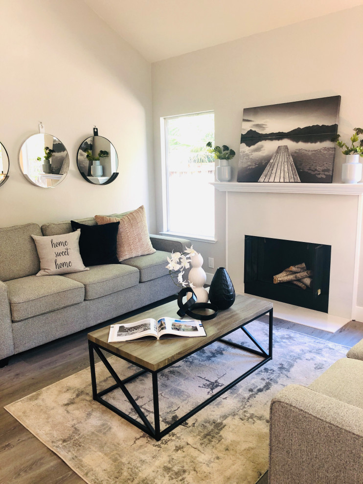 Medium sized modern enclosed living room in San Francisco with grey walls, medium hardwood flooring, a standard fireplace, a tiled fireplace surround, no tv and brown floors.