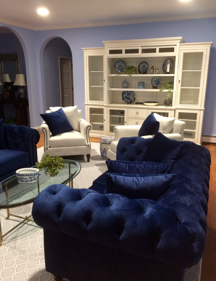Esempio di un grande soggiorno chic aperto con pareti blu, pavimento in legno massello medio, TV a parete e pavimento marrone