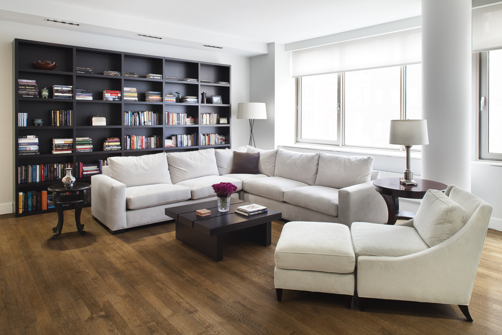 Idee per un grande soggiorno design con libreria e pareti bianche