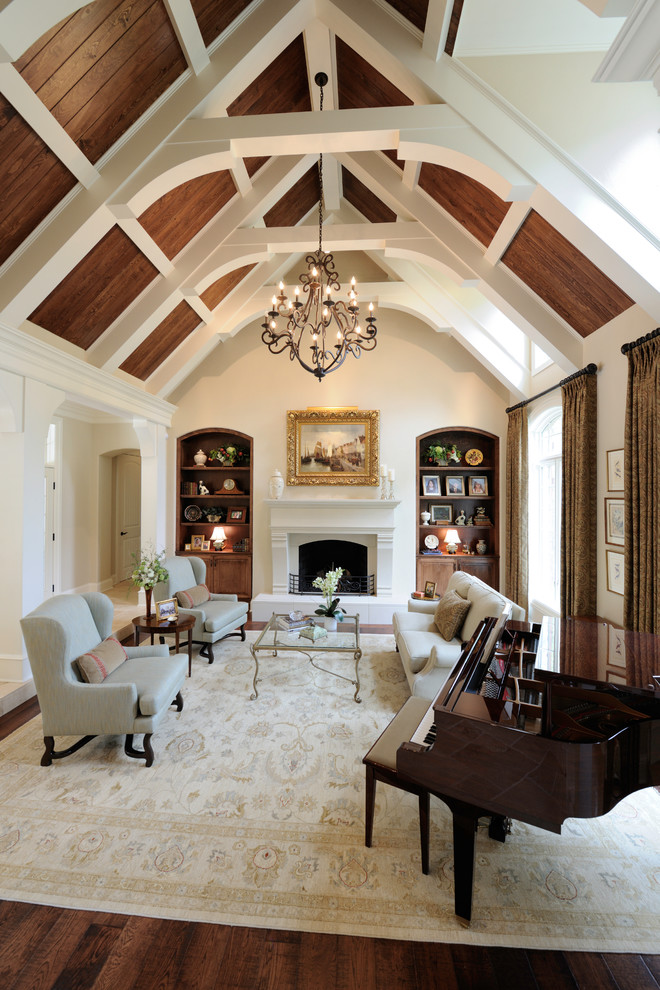 На фото: парадная гостиная комната в классическом стиле с белыми стенами, паркетным полом среднего тона, стандартным камином и ковром на полу с