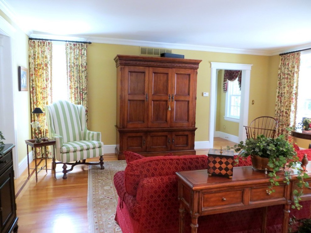 Mittelgroßes, Offenes Klassisches Wohnzimmer ohne Kamin mit gelber Wandfarbe, braunem Holzboden und verstecktem TV in New York