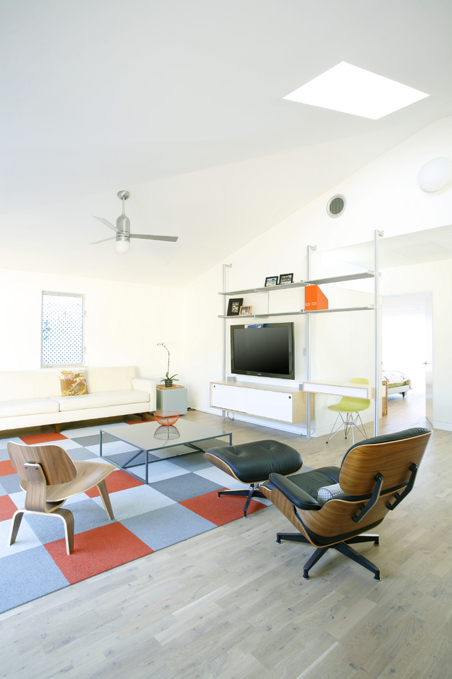 Идея дизайна: гостиная комната в скандинавском стиле с белыми стенами и телевизором на стене