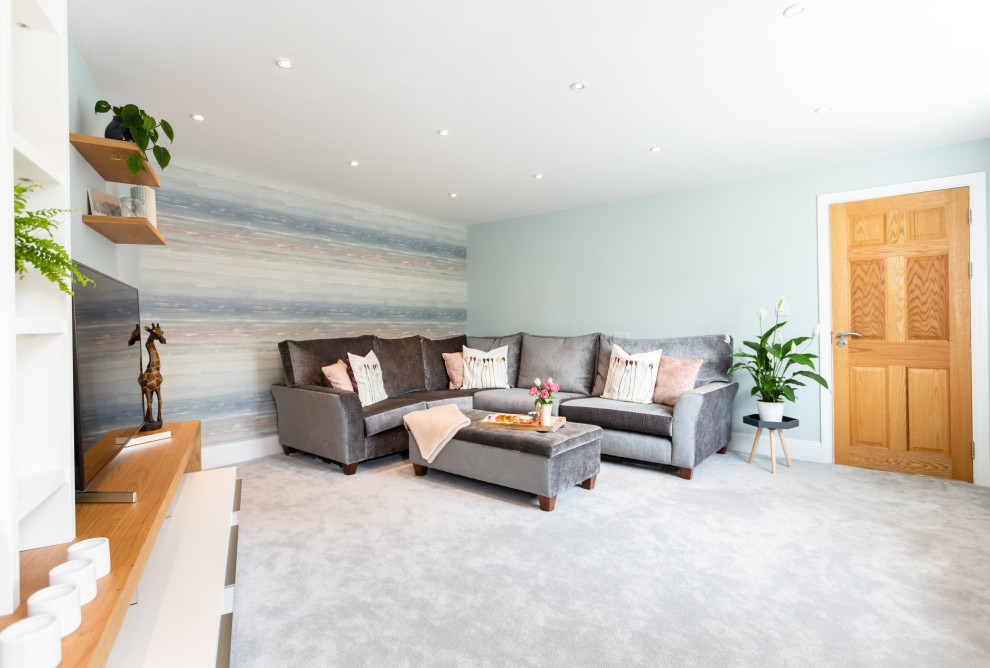 Großes, Abgetrenntes Klassisches Wohnzimmer ohne Kamin mit blauer Wandfarbe, Teppichboden, freistehendem TV und grauem Boden in Sonstige