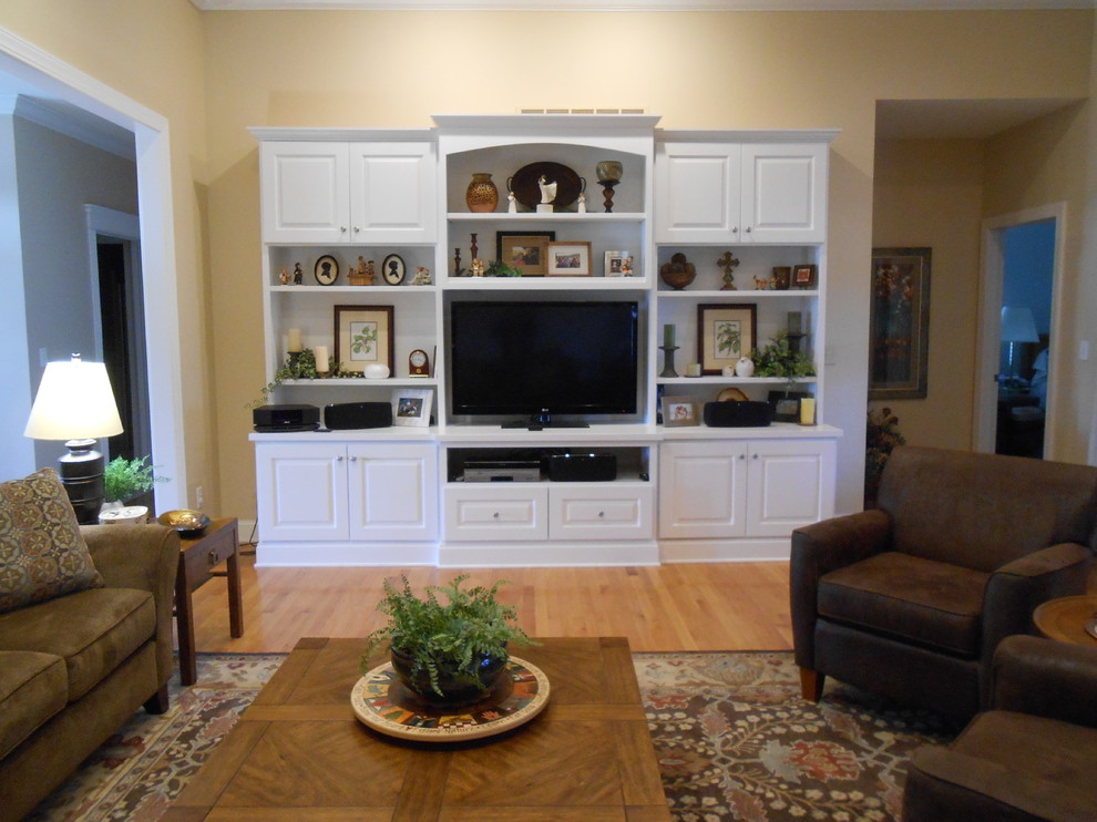 Idee per un soggiorno chic di medie dimensioni e chiuso con pareti beige, parquet chiaro, parete attrezzata e pavimento beige