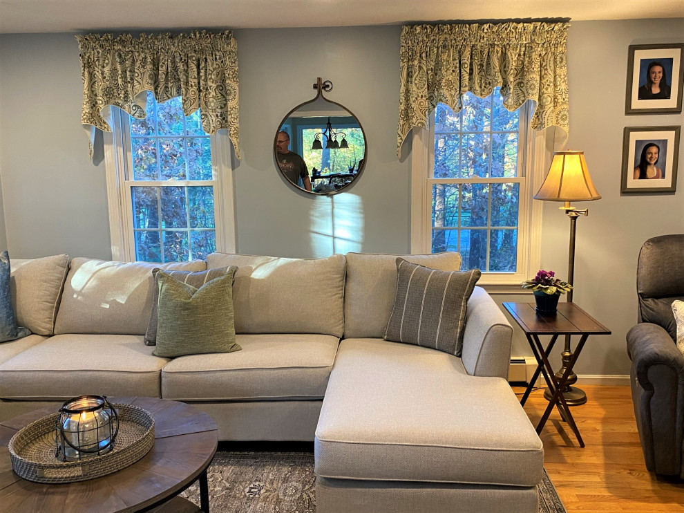 Exempel på ett mellanstort klassiskt vardagsrum, med blå väggar, ljust trägolv och en fristående TV