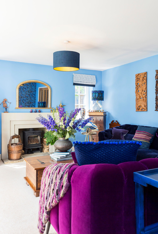 Großes Stilmix Wohnzimmer mit blauer Wandfarbe, Teppichboden, Kaminofen, Kaminumrandung aus Stein und Tapetenwänden in Surrey