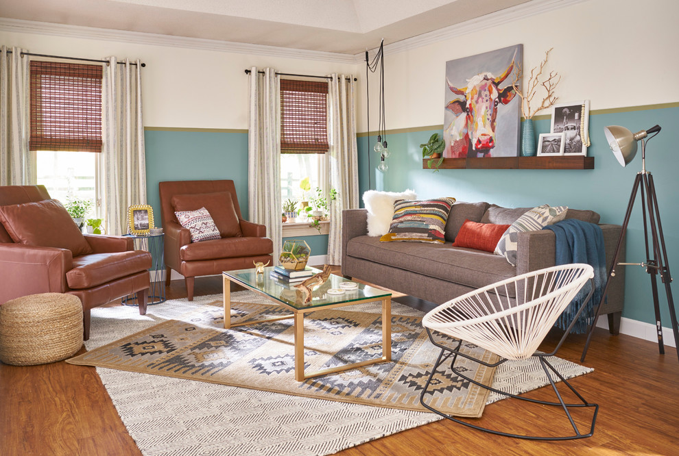 Imagen de salón cerrado bohemio de tamaño medio sin chimenea y televisor con paredes verdes, suelo laminado y suelo marrón