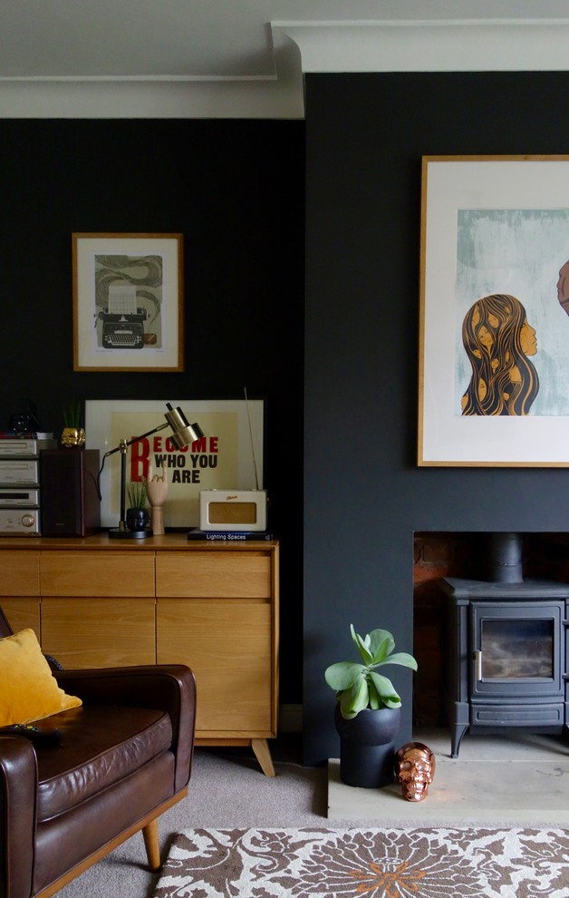 Réalisation d'un salon vintage de taille moyenne et fermé avec un mur noir, moquette, un poêle à bois, un manteau de cheminée en plâtre et un téléviseur indépendant.