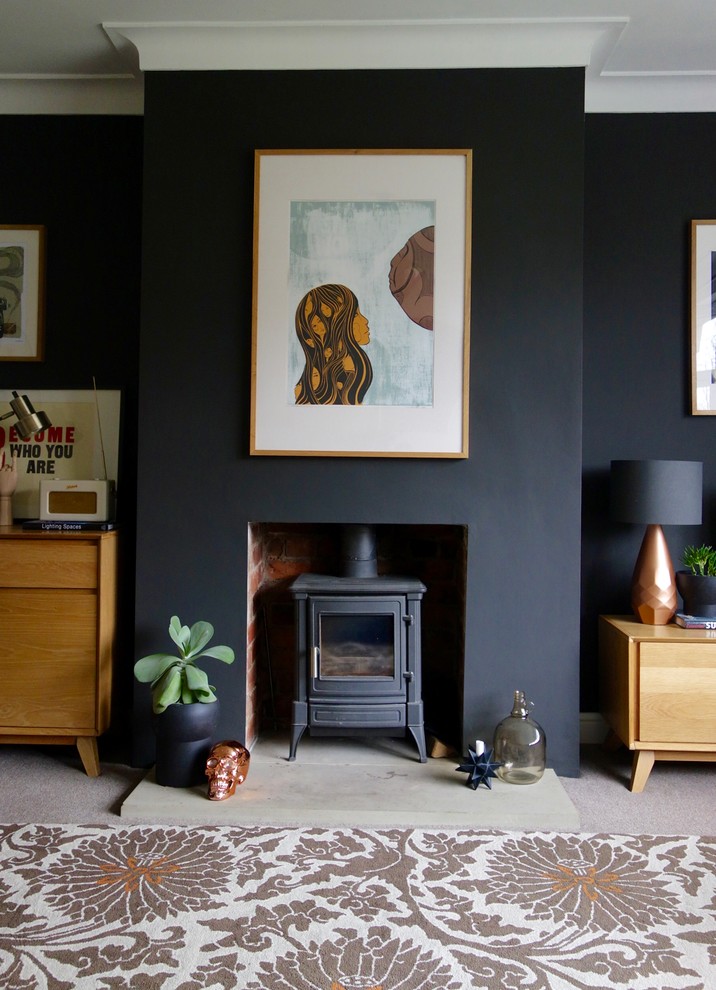 Свежая идея для дизайна: изолированная гостиная комната среднего размера в стиле ретро с черными стенами, ковровым покрытием, печью-буржуйкой и отдельно стоящим телевизором - отличное фото интерьера