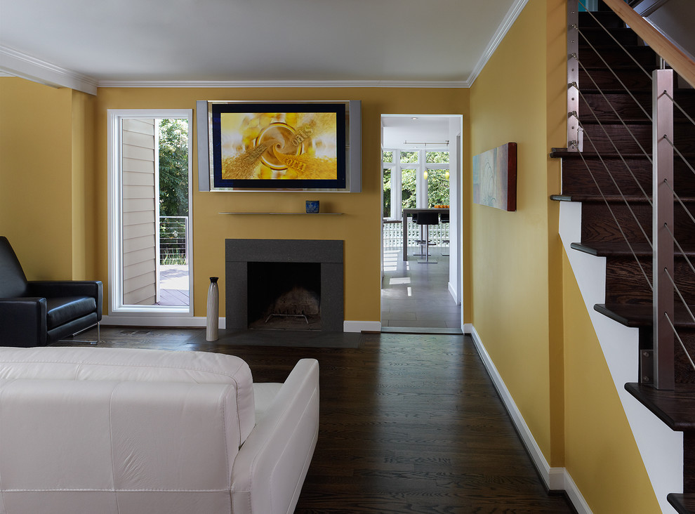 ワシントンD.C.にあるコンテンポラリースタイルのおしゃれなリビング (標準型暖炉、壁掛け型テレビ、黒い床) の写真