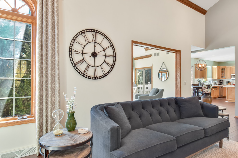 Foto de salón para visitas abierto minimalista grande con paredes grises, suelo de madera en tonos medios, estufa de leña, marco de chimenea de ladrillo y suelo marrón