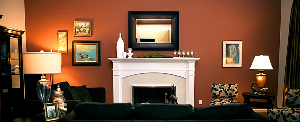 サンフランシスコにあるラグジュアリーな広いトランジショナルスタイルのおしゃれなリビング (オレンジの壁、標準型暖炉、テレビなし、カーペット敷き、石材の暖炉まわり) の写真