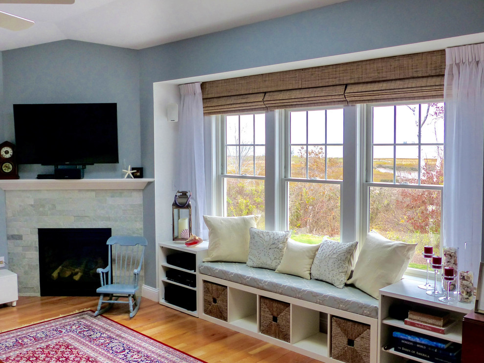 Exempel på ett mellanstort modernt allrum med öppen planlösning, med blå väggar, mellanmörkt trägolv, en öppen hörnspis, en spiselkrans i sten, en väggmonterad TV och flerfärgat golv
