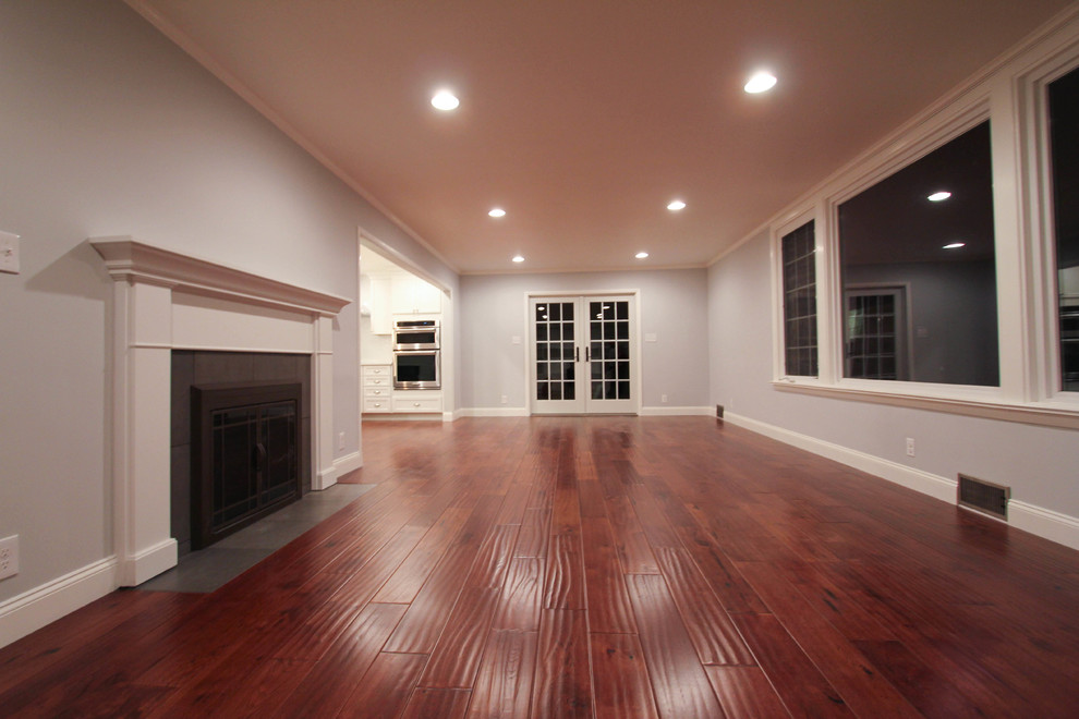 Großes, Offenes Landhausstil Wohnzimmer mit grauer Wandfarbe, braunem Holzboden und TV-Wand in Philadelphia