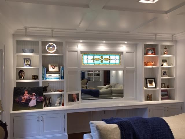Пример оригинального дизайна: большая двухуровневая гостиная комната в классическом стиле с с книжными шкафами и полками, белыми стенами, паркетным полом среднего тона, стандартным камином, фасадом камина из кирпича и коричневым полом без телевизора