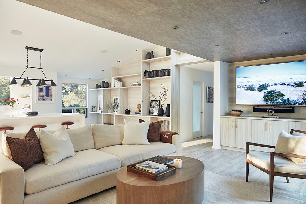 Diseño de salón para visitas abierto minimalista con paredes blancas, suelo de madera clara y pared multimedia