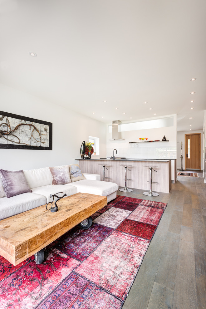 Mittelgroßes, Offenes Modernes Wohnzimmer mit Hausbar, weißer Wandfarbe, braunem Holzboden, Eckkamin, verputzter Kaminumrandung und TV-Wand in Toronto