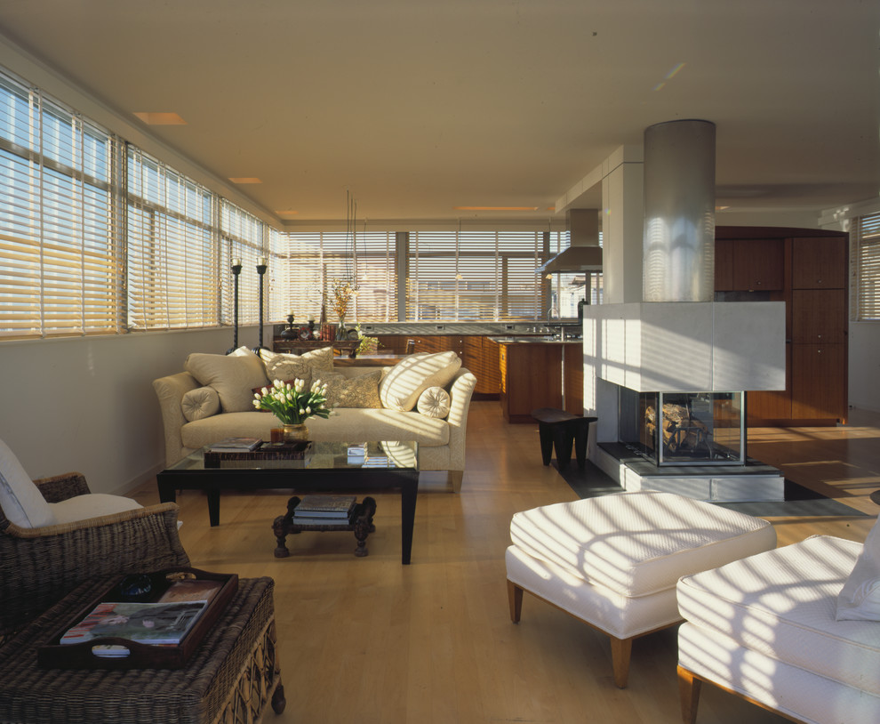 Идея дизайна: большая двухуровневая гостиная комната в современном стиле с белыми стенами, ковровым покрытием, двусторонним камином и бежевым полом