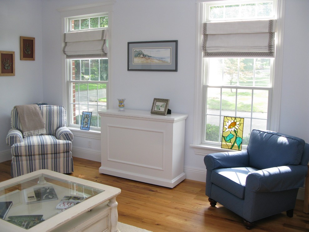 This is an example of a medium sized coastal enclosed living room in Other with white walls and light hardwood flooring.