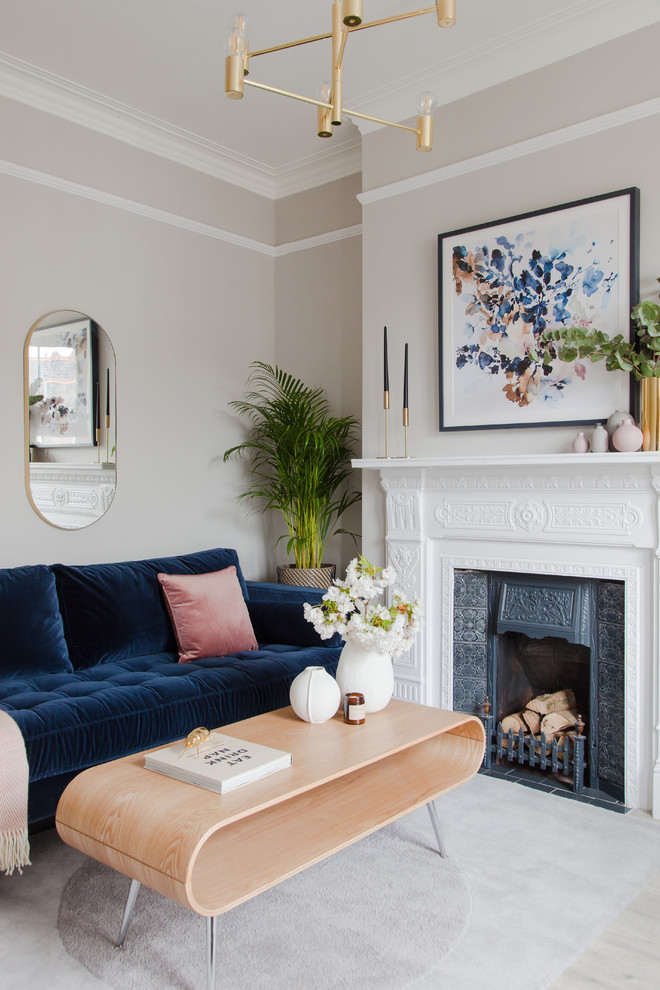 Стильный дизайн: парадная гостиная комната в стиле неоклассика (современная классика) с серыми стенами, ковровым покрытием, стандартным камином, фасадом камина из металла, серым полом и синим диваном без телевизора - последний тренд