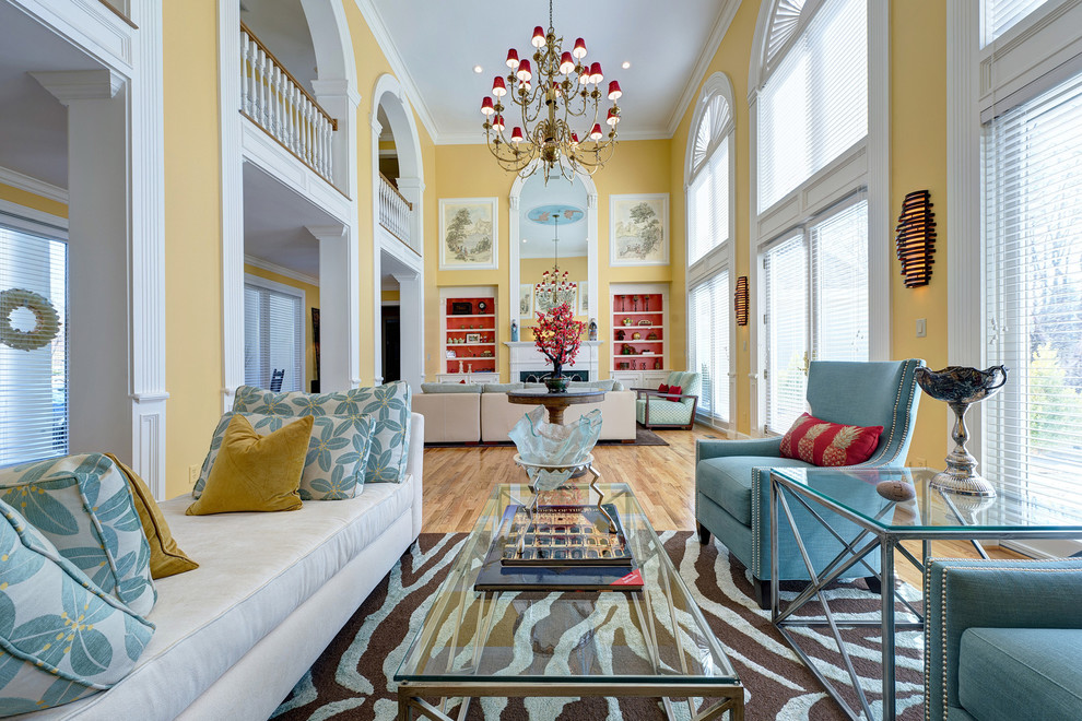 Стильный дизайн: большая открытая гостиная комната в стиле фьюжн с желтыми стенами, светлым паркетным полом, стандартным камином и коричневым полом без телевизора - последний тренд