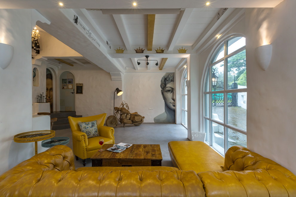 Immagine di un soggiorno mediterraneo con pareti bianche, pavimento in cemento e pavimento grigio