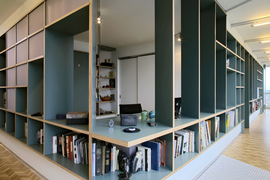 Пример оригинального дизайна: большая открытая гостиная комната в современном стиле с с книжными шкафами и полками, синими стенами, пробковым полом и белым полом