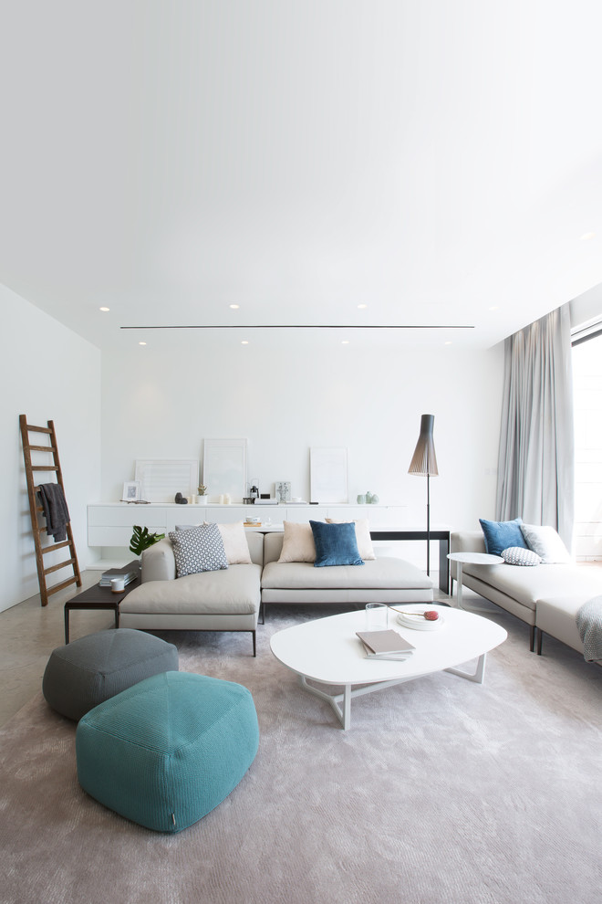 Inspiration pour un salon minimaliste ouvert avec un mur jaune, un sol en calcaire et un téléviseur encastré.