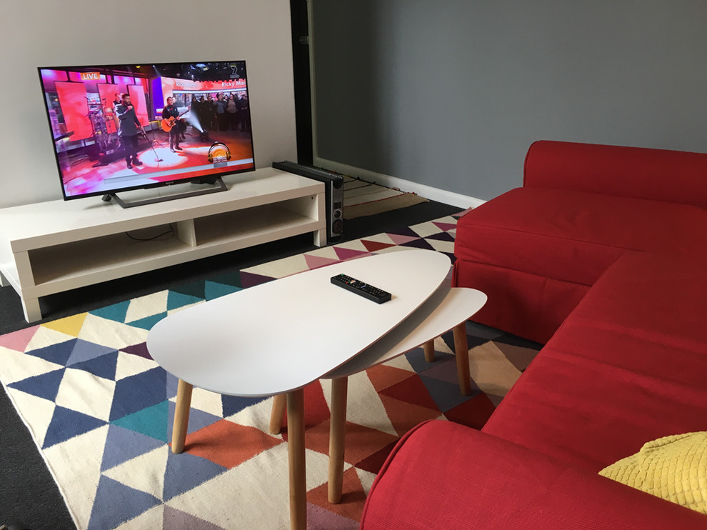 Kleines, Offenes Eklektisches Wohnzimmer ohne Kamin mit grauer Wandfarbe, Teppichboden und freistehendem TV in Melbourne