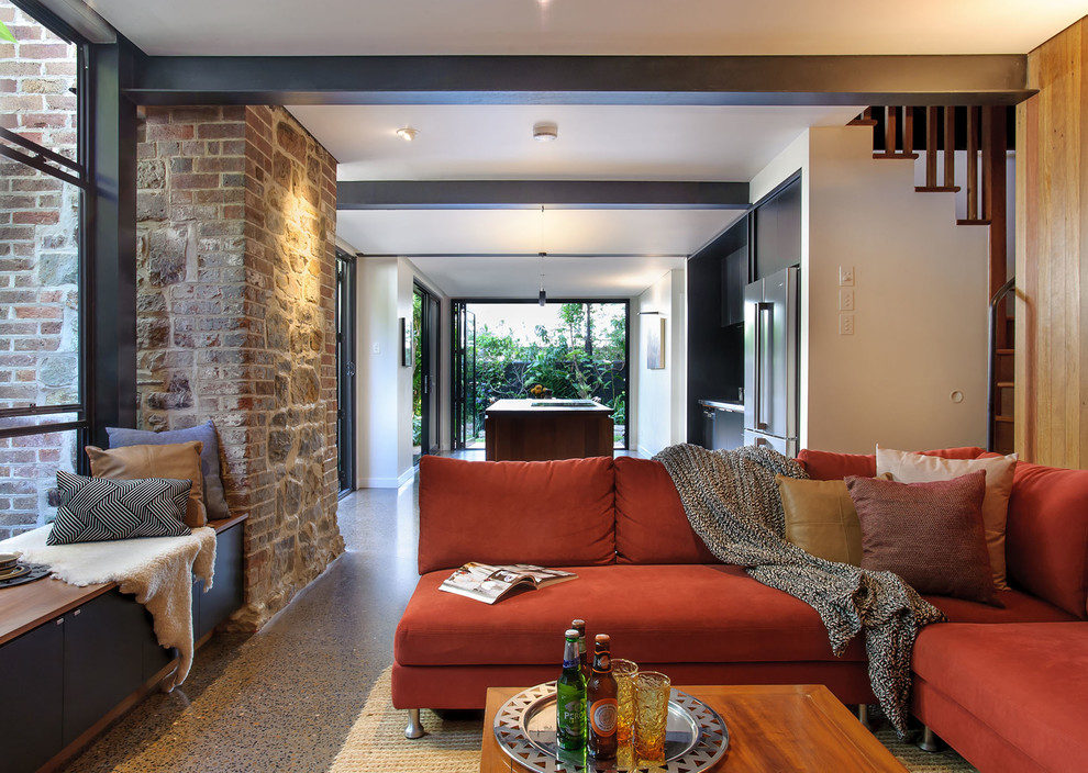 Esempio di un soggiorno design di medie dimensioni e aperto con pavimento in cemento, pavimento grigio, pareti marroni e TV a parete
