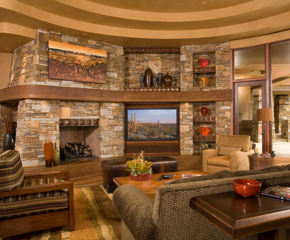 На фото: гостиная комната в классическом стиле с стандартным камином, фасадом камина из камня, мультимедийным центром и коричневым диваном